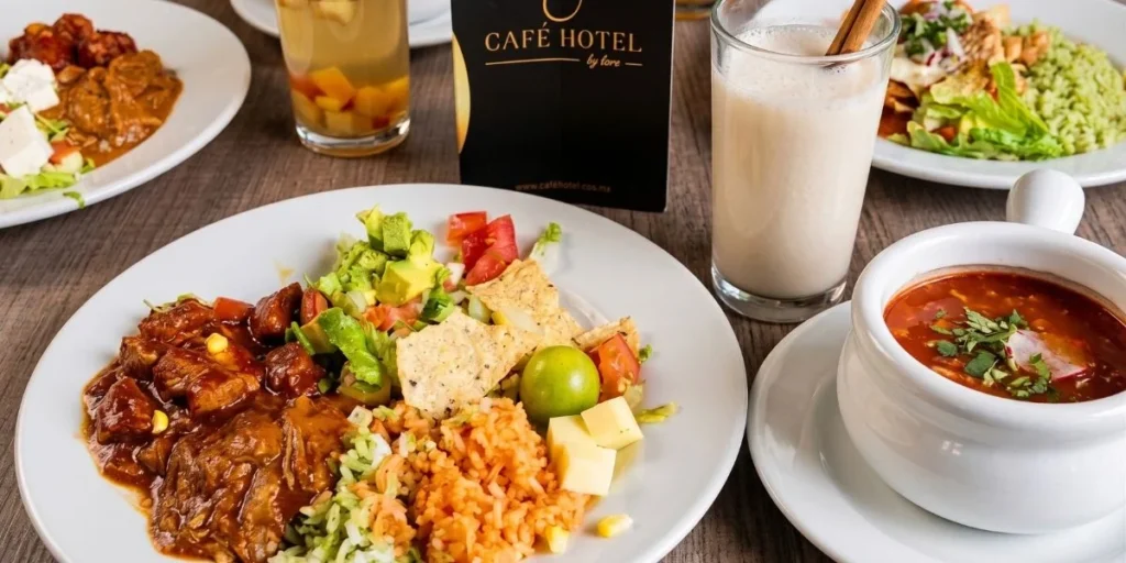 Plato típico colombiano en Café Hotel Medellín: arroz, carne, aguacate y sopa en ambiente de lujo.