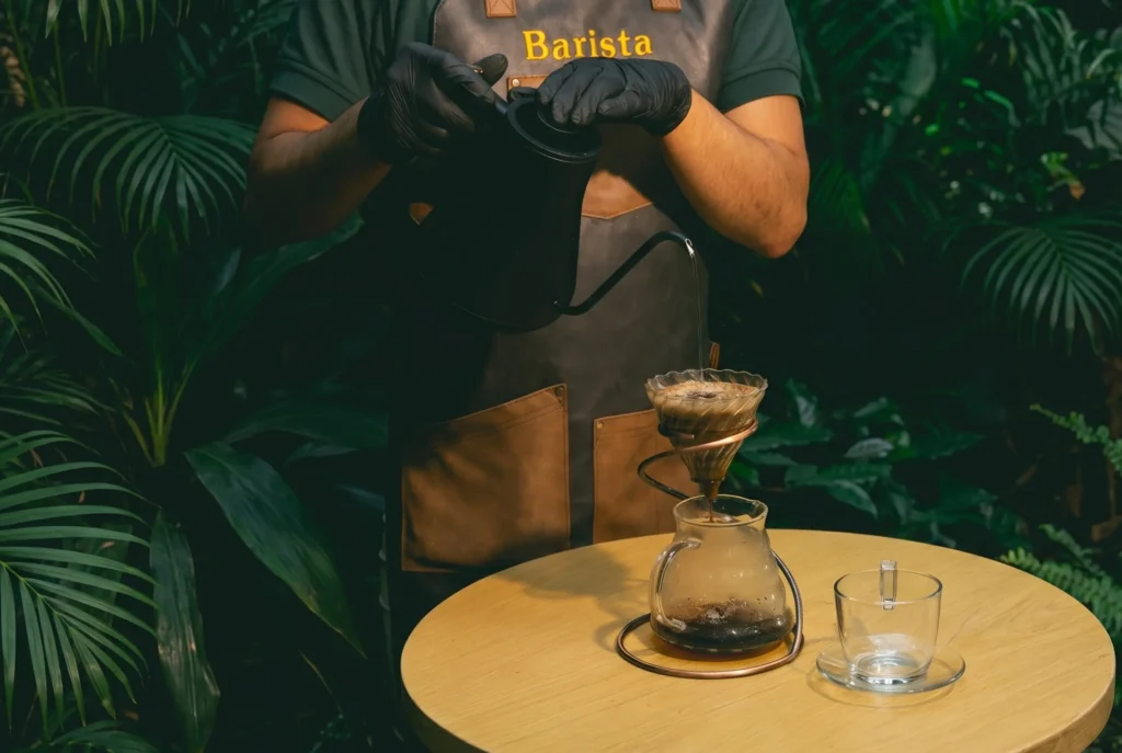 Barista preparando pour over con cafe colombiano en Cofy Club Cafe Hotel Medellin