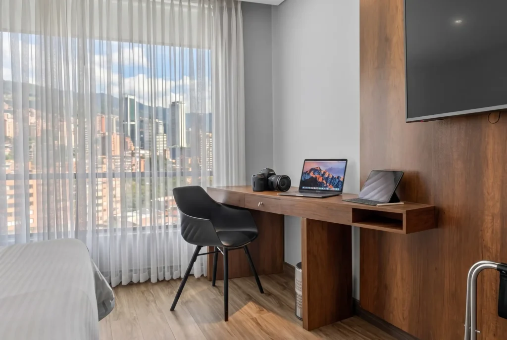 Escritorio con laptop camara y tablet en habitacion de Cafe Hotel Medellin El Poblado