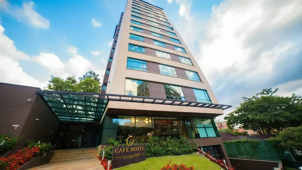 Fachada exterior de Cafe Hotel Medellin El Poblado con jardin y entrada principal