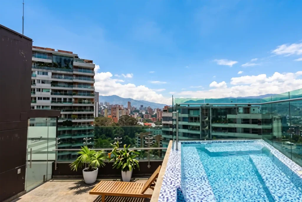 Piscina en terraza de Café Hotel Medellín con vista panorámica a El Poblado y las montañas