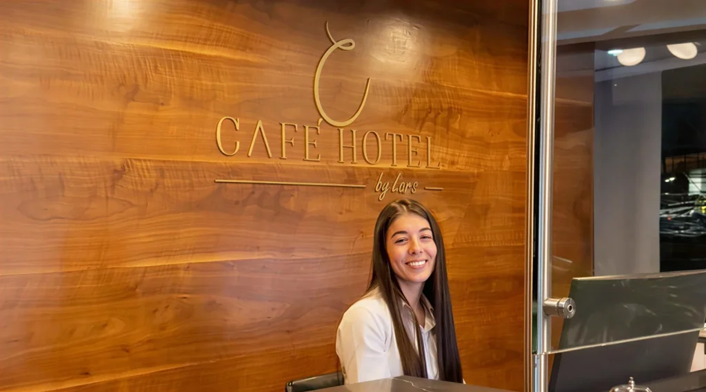 Recepcionista en el lobby de Café Hotel Medellín El Poblado con logo by Lars