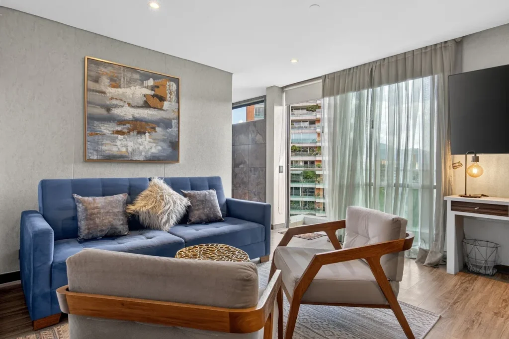 Suite at Café Hotel with a blue sofa and a view of El Poblado, Medellín